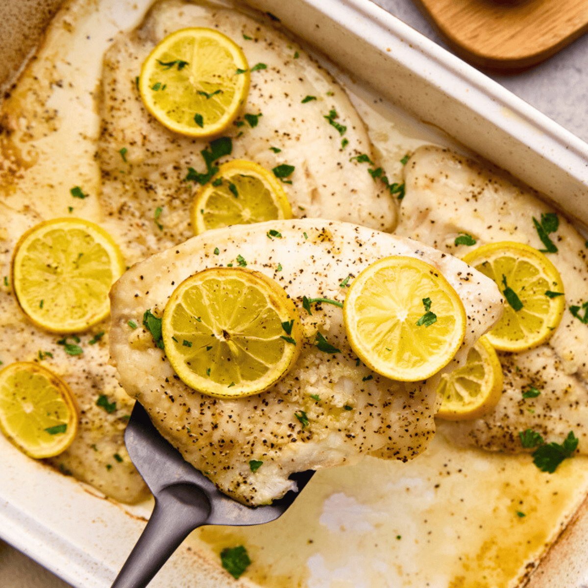 Easy Lemon Garlic Baked Tilapia on a spatula.