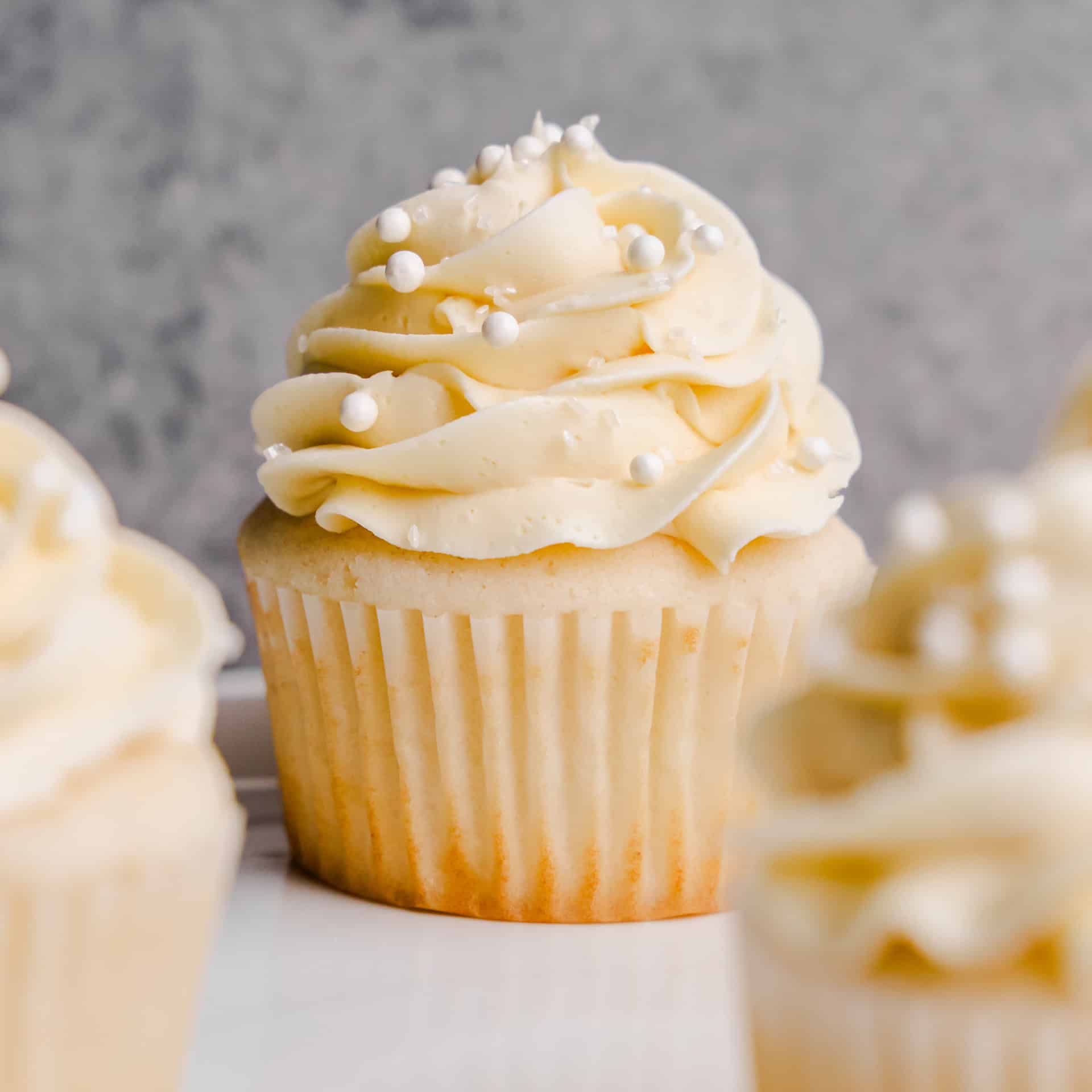 A Most Amazing White Cupcakes with crystal sugar and white sprinkles.