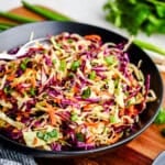 Spicy Sesame Coleslaw in a black serving bowl.