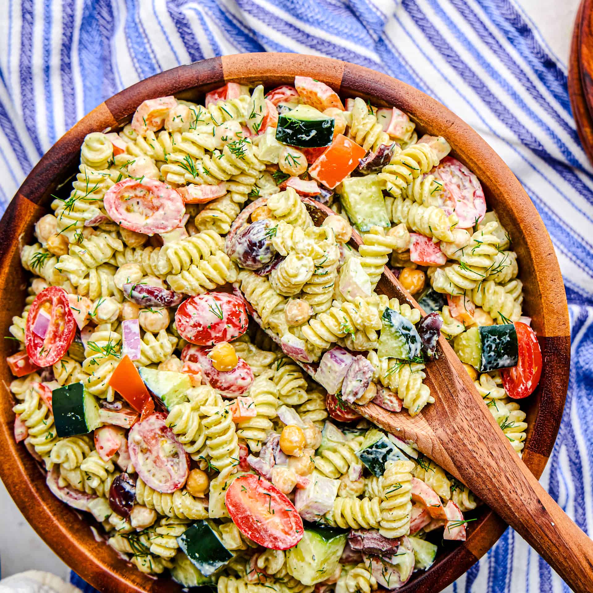 Overhead image of Whipped Feta Greek Pasta Salad in a large wooden serving bowl.