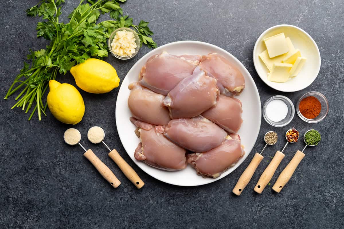 An overhead view of the ingredients needed to make crockpot lemon garlic butter chicken thighs.