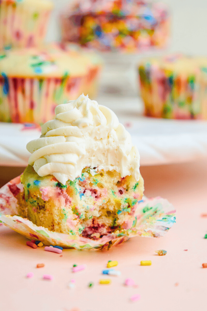 A Funfetti Birthday Cupcakes with a bite taken out of it.