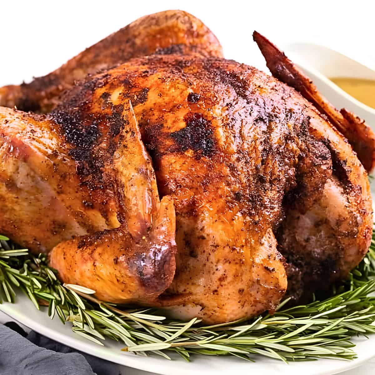 A juicy roasted turkey on a serving platter with perfectly golden, crispy skin.